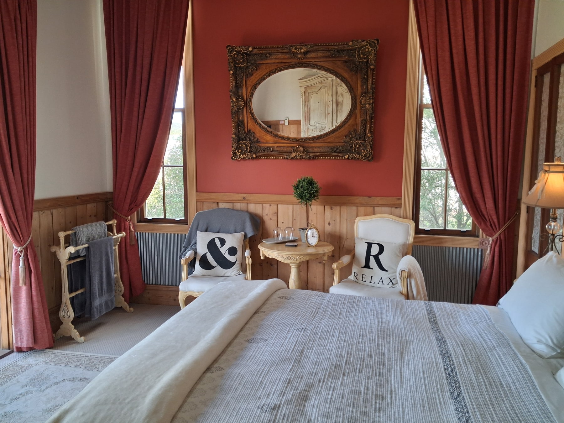 La Chambre bedroom sitting area framed by rich red curtains
